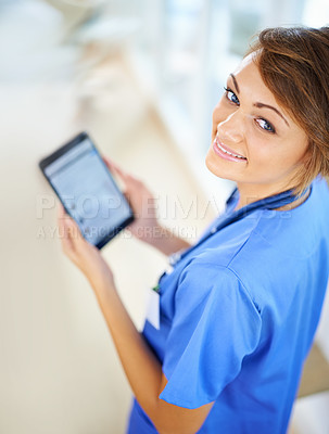 Buy stock photo Portrait of an attractive young doctor in scrubs holding a digital tablet