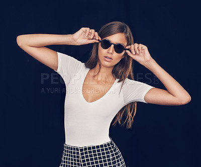 Buy stock photo Studio shot of an attractive young woman holding her sunglasses