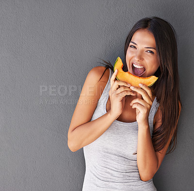 Buy stock photo Shot of a beautiful young woman eating a slice of melon