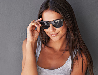 Buy stock photo Shot of a beautiful young woman wearing sunglasses being flirty