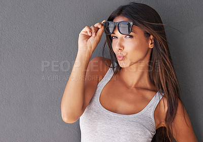 Buy stock photo Kiss, portrait or woman with sunglasses or fashion in studio on grey background for cool eyewear or modern style. Model, lady flirting or confident person with stylish accessory, pride or edgy shades