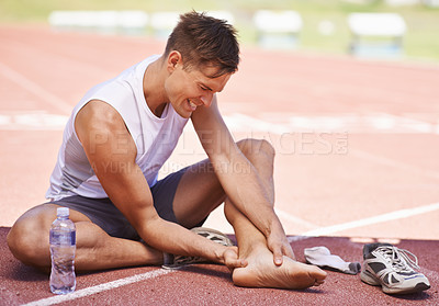 Buy stock photo Shot of an athlete feeling the pain of an ankle injury