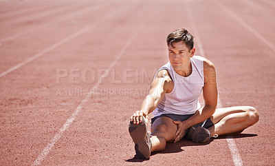 Buy stock photo Shot of an athlete stretching his legs while sitting on the track