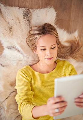 Buy stock photo Tablet, app and social media with woman on floor of home for browsing or communication from above. Face, technology and relax with young person in living room of apartment for weekend free time
