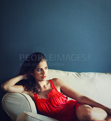 Buy stock photo Relax, sexy and space with woman on sofa in studio on blue background for feminine wellness. Beauty, fashion and thinking with confident or serious young person in red dress for valentines day