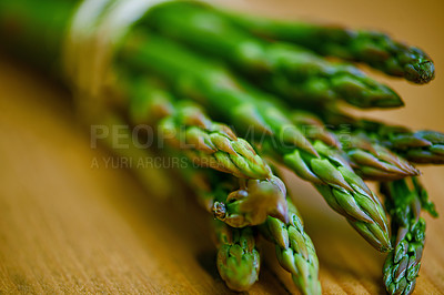 Buy stock photo Asparagus, closeup and counter for health, wellness or organic diet on wood countertop. Vegetable, nutrition or produce for eating, gourmet and meal or cuisine with vitamins or fibre for weight loss