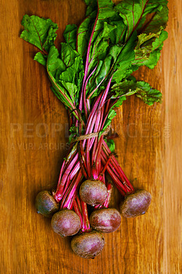 Buy stock photo Beetroot, closeup and counter for nutrition, wellness or organic diet on wood countertop. Vegetable, health or produce for eating, gourmet and meal or cuisine with vitamins or fibre for weight loss