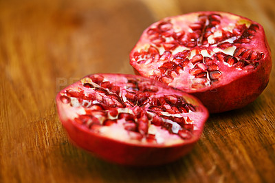 Buy stock photo Food, fruit and pomegranate on wooden table in kitchen for diet, health or nutrition closeup. Wellness, minerals and vitamins with healthy produce on counter or surface in apartment for detox