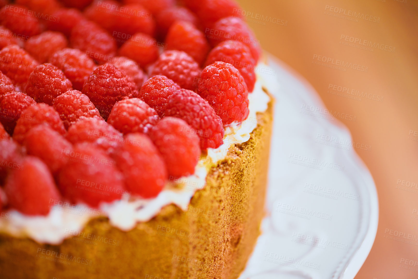 Buy stock photo Plate, frosting and cheesecake with raspberries on table for sweet snack for tea time at home. Bakery, catering and closeup of gourmet dessert with crust, cream and fresh organic fruit in dining room