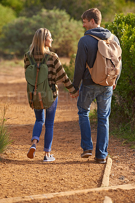 Buy stock photo Path, hiking and happy couple holding hands in nature for holiday, travel or adventure outdoor with backpack. Rear view, man or woman trekking in the countryside on vacation, journey or date together