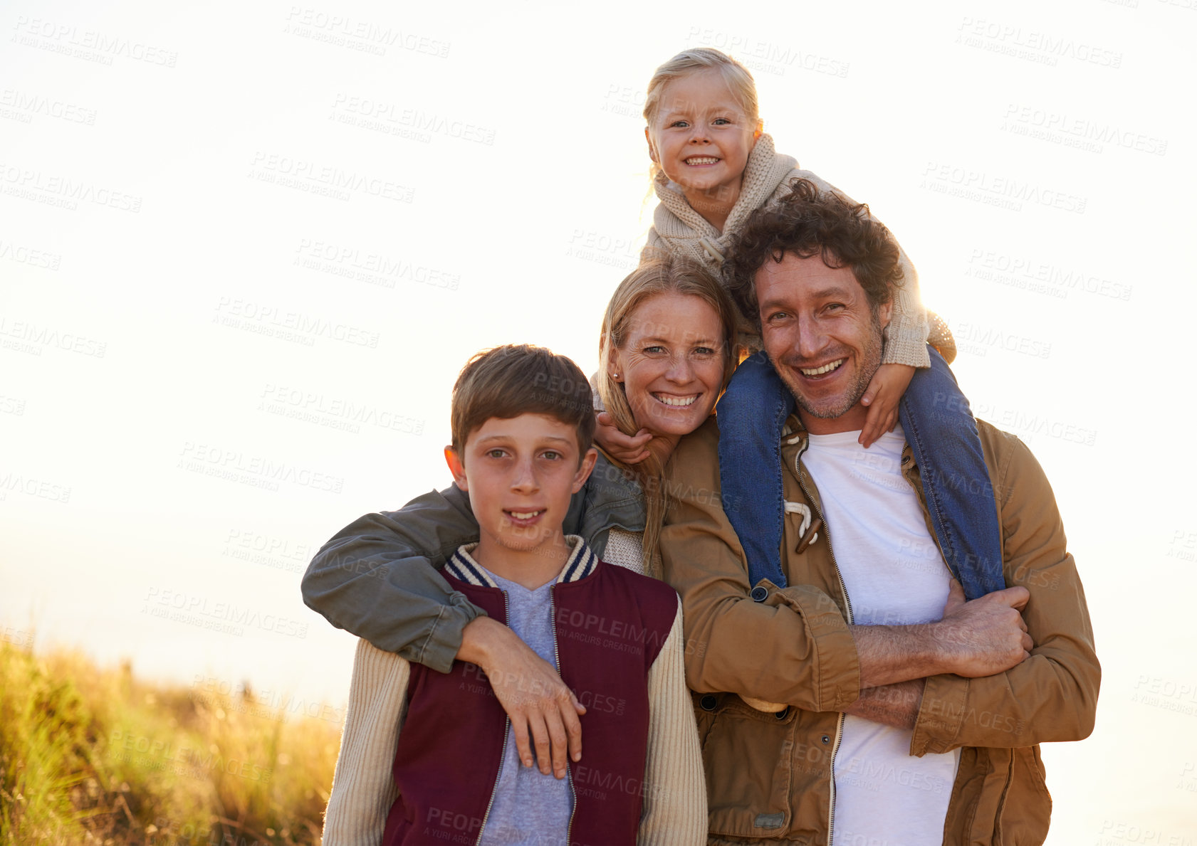 Buy stock photo Family, portrait and smile with field, walk and sunrise for morning exercise and bond. Parents, children and countryside for health, wellness and outdoor adventure at sunset for holiday or vacation.