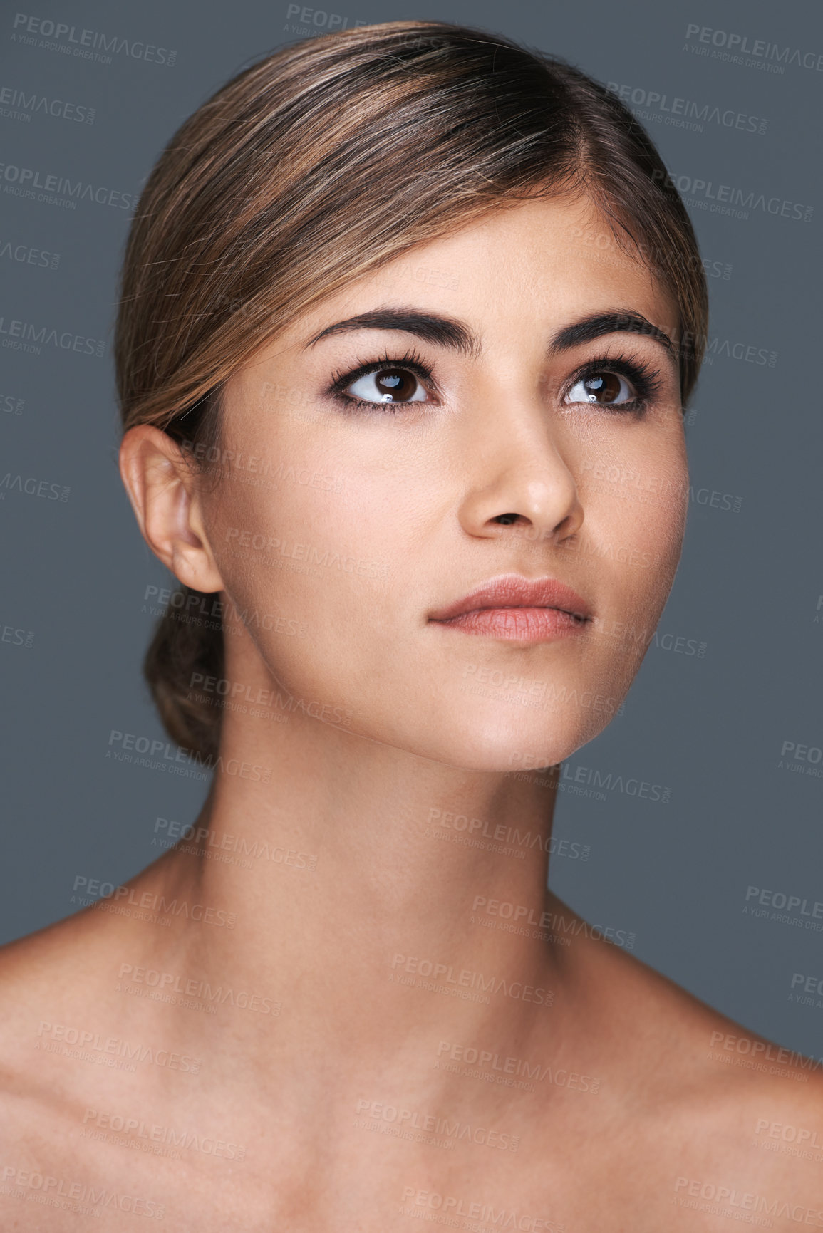 Buy stock photo A cropped shot of a beautiful young woman looking up isolated on grey