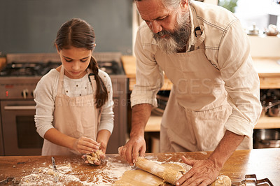 Buy stock photo Shot of a girl and her grandfather baking together in the kitchen