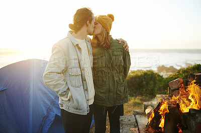 Buy stock photo Camping, fire and kissing with couple on beach together for holiday, romance or vacation in summer. Nature, sunset or tent with young man and woman hugging at coast by ocean or sea for adventure