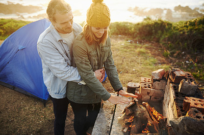 Buy stock photo Nature, sunset and couple with fire for camping on romantic vacation, adventure or holiday. Happy, love and young man and woman with flame for warm on winter weekend trip with tent together.