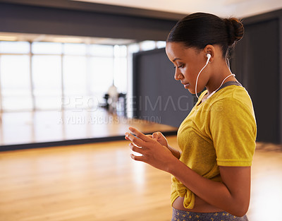 Buy stock photo Relax, girl and listening to music with earphones connect on digital device in dance studio or gym in weekend. Audio, female person and woman streaming songs on app with technology and sound