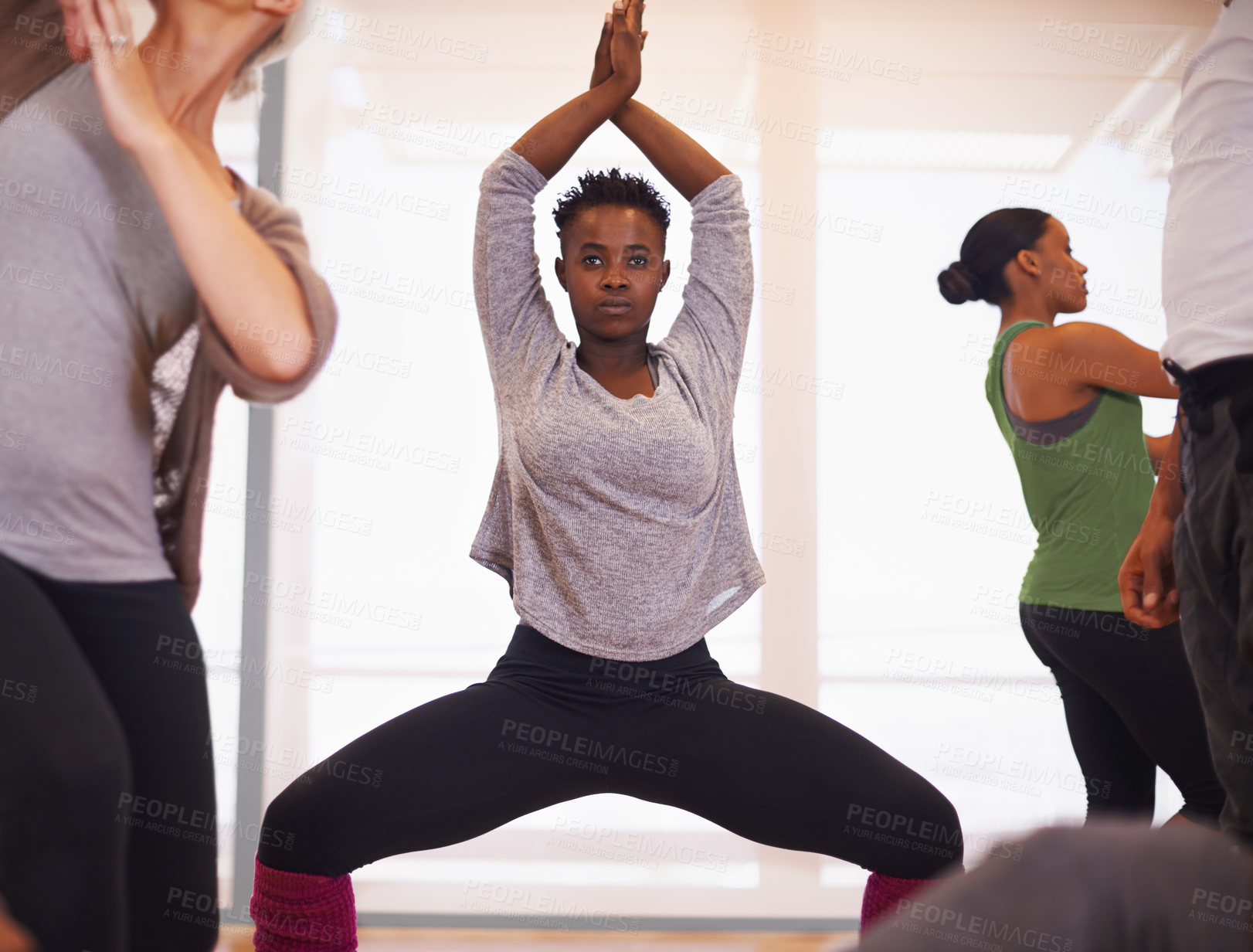 Buy stock photo Black woman, yoga and stretching with team in class for workout, exercise or indoor training together. African female person, coach or instructor in body warm up with group in fitness for wellness