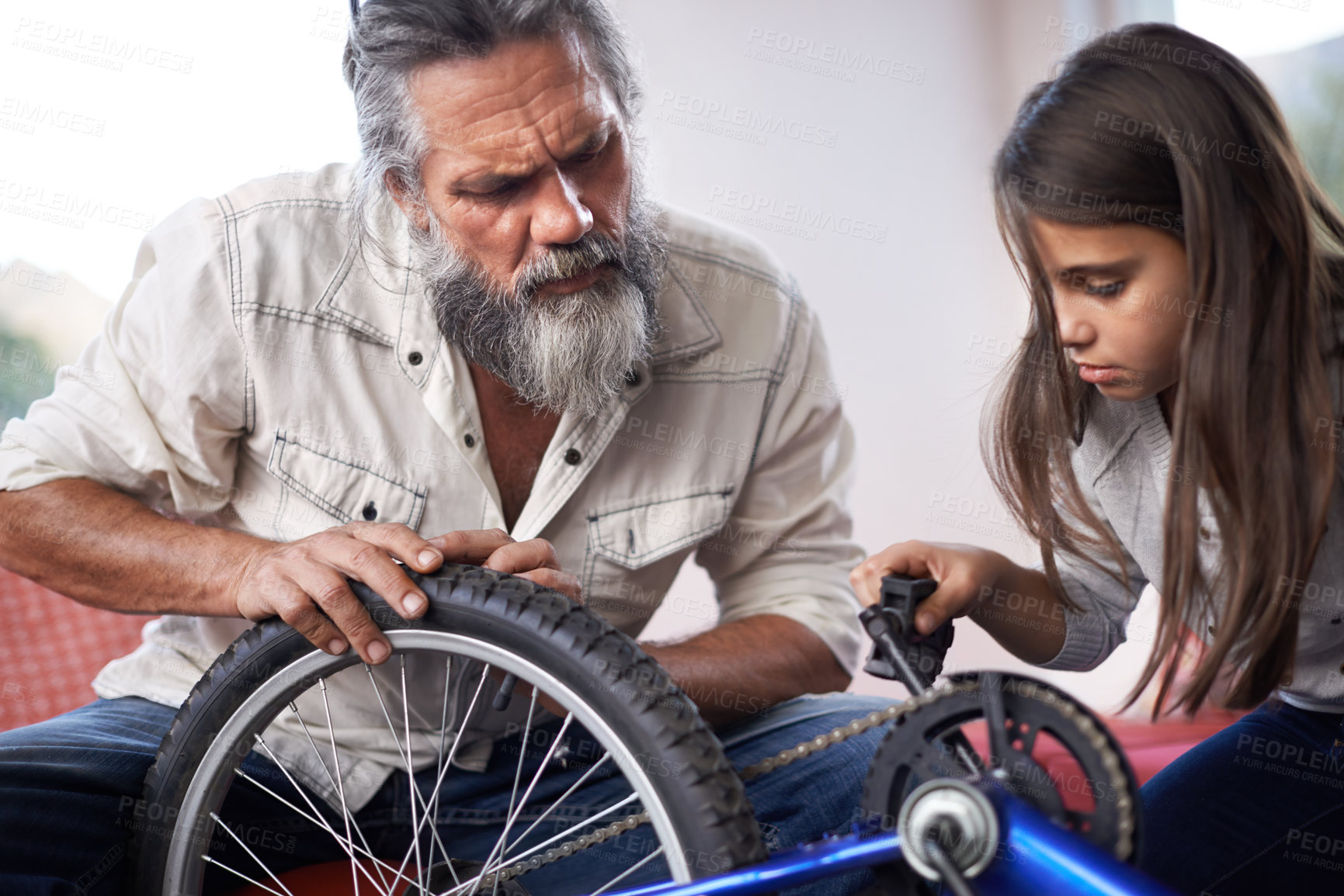 Buy stock photo Cropped shot of a senior man helping his granddaughter with her bike
