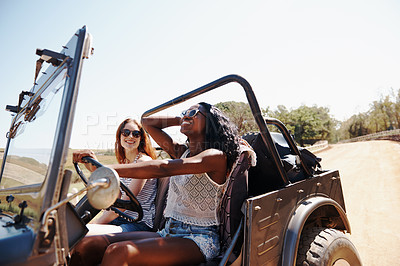 Buy stock photo Shot of two young woman enjoying a roadtrip together