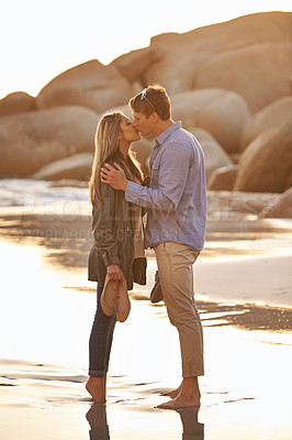 Buy stock photo Couple, kiss and love in embrace by water, ocean waves and peace for romance in relationship. People, affection and security in marriage, sea hug and travel together on vacation or holiday for date