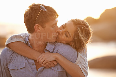 Buy stock photo Couple, kiss and love in hug at beach, ocean waves and peace for romance in relationship. People, affection and security in marriage, sea embrace and travel together on vacation or holiday for date