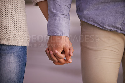 Buy stock photo Cropped shot of a couple holding hands outdoors
