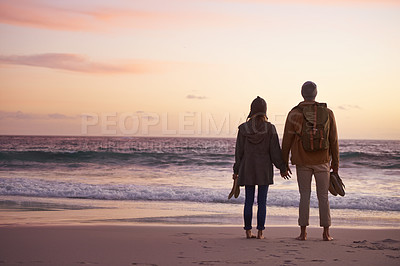 Buy stock photo Shot of a couple enjoying a romantic evening on the beach at sunset