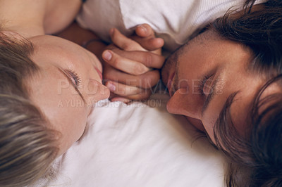 Buy stock photo Cropped shot of an affectionate young couple sleeping while holding hands