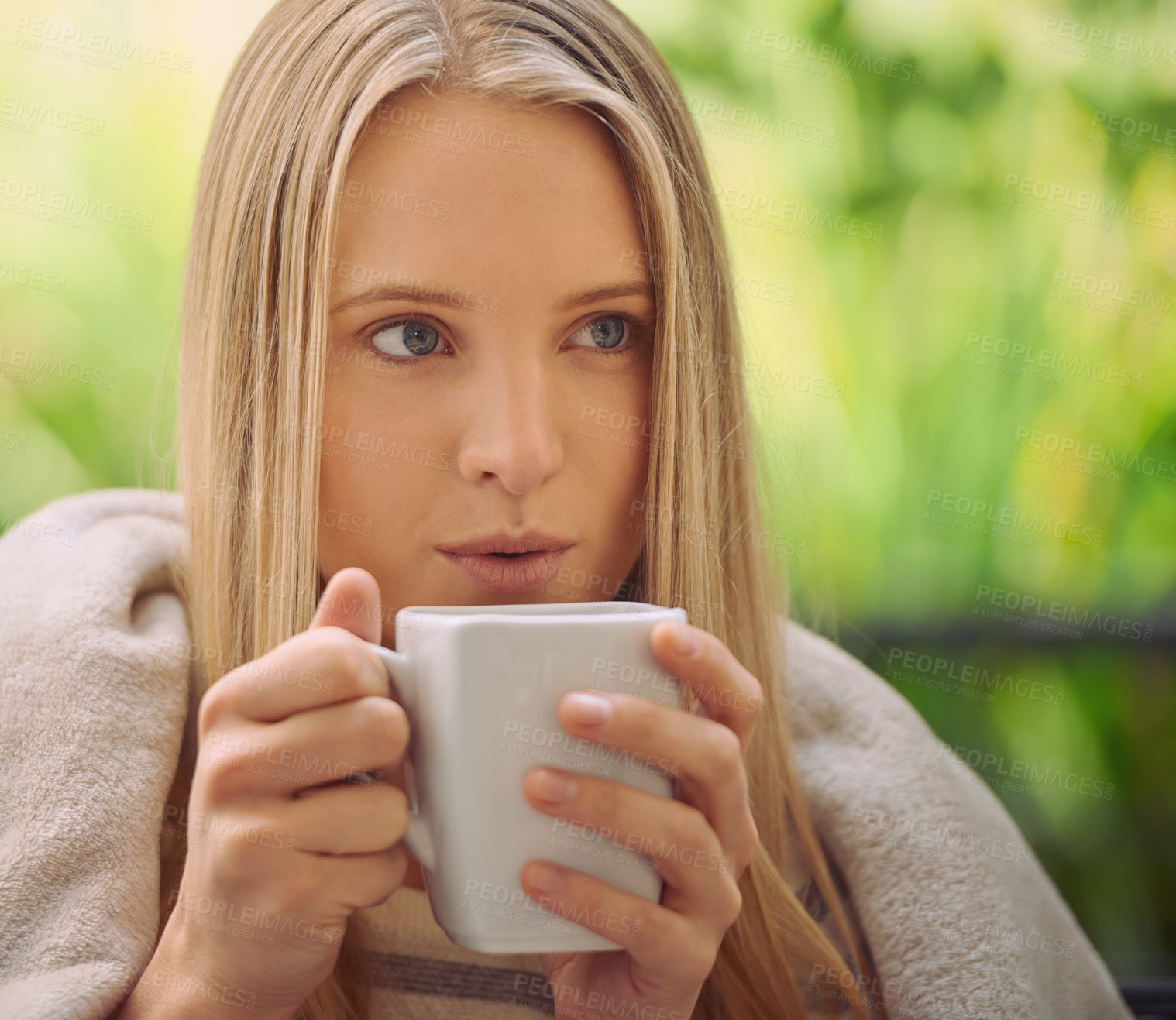 Buy stock photo Shot of a young woman drinking a cup of coffee outside