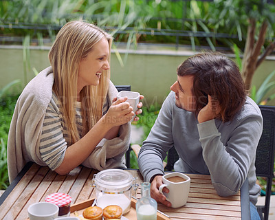 Buy stock photo A happy young couple having coffee together in the morning