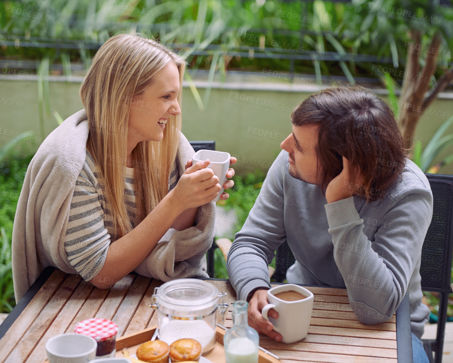 Buy stock photo A happy young couple having coffee together in the morning