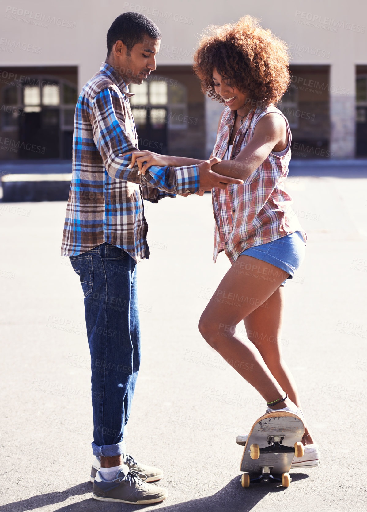 Buy stock photo Happy, learning and man with woman on skateboard in city on romantic and fun date together. Smile, couple and African male skater teaching skating to young girlfriend in urban town with love.