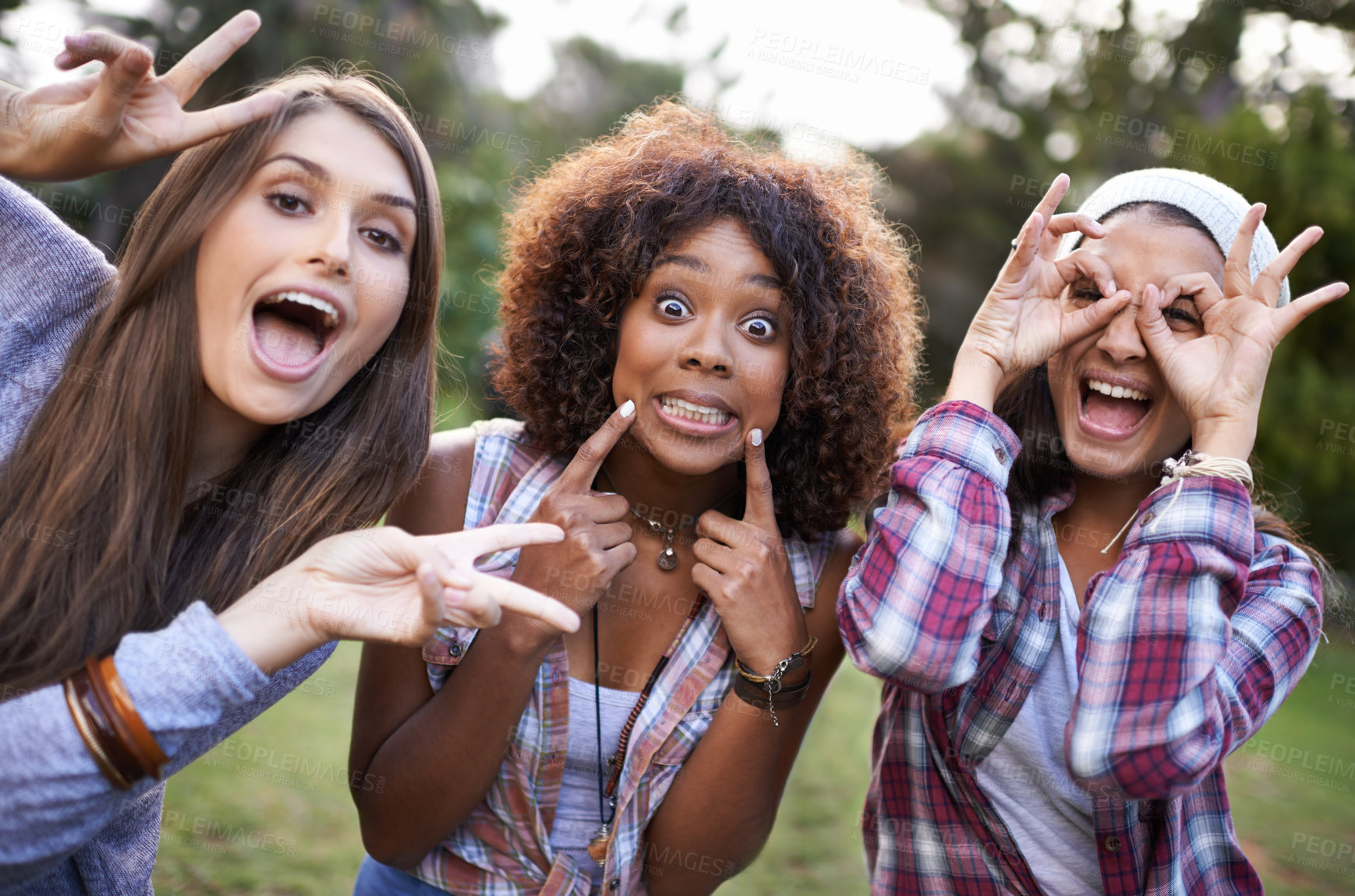 Buy stock photo Cropped portrait of a group of girl friends pulling funny faces while at the park