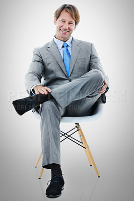 Buy stock photo Businessman, portrait and sitting with chair in relax for interview or career opportunity on a gray studio background. Man or employee with smile in fashion, style or job for startup on mockup space