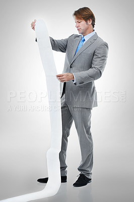Buy stock photo Businessman, documents and receipt with finance for bills, expenses or list on a gray studio background. Man or employee checking financial paperwork or report for audit or budget planning on mockup