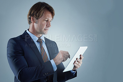 Buy stock photo Businessman, tablet and smile in studio with technology, connectivity and reading online on app. Gray background, professional and mature man with touch screen for social media and research in mockup