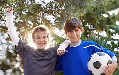 Buy stock photo Shot of two young boys standing outside with a soccer ball