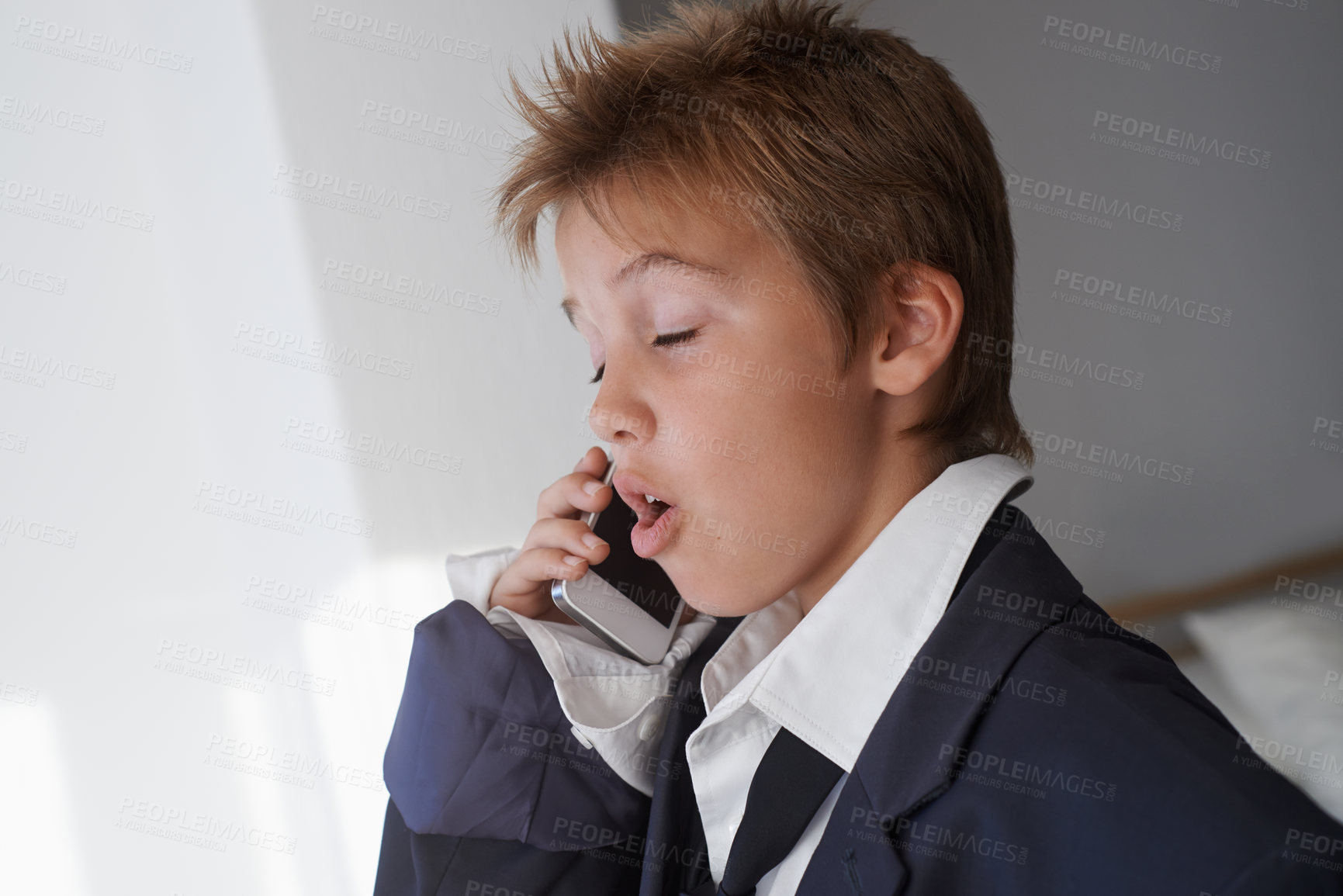 Buy stock photo Shot of a young boy wearing his father's suit and pretending to be a businessman