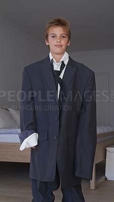 Buy stock photo Portrait, boy and pretend suit on male person, oversized business clothes for dream job on child. Dress up, kid and happy smile on career day for school, costume and standing in home bedroom