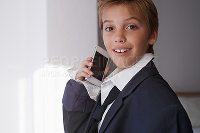 Buy stock photo Child, portrait and phone call in suit for communication connection or dress up costume, home or working. Male person, face and smartphone conversation in apartment for corporate, talking or happy