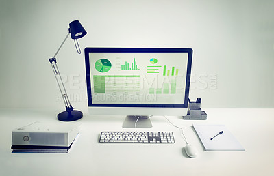 Buy stock photo Workspace, computer screen and notebook in room with light for remote work, infographics or data analytics. Workplace, monitor and documents on desk with keyboard for financial career and statistics