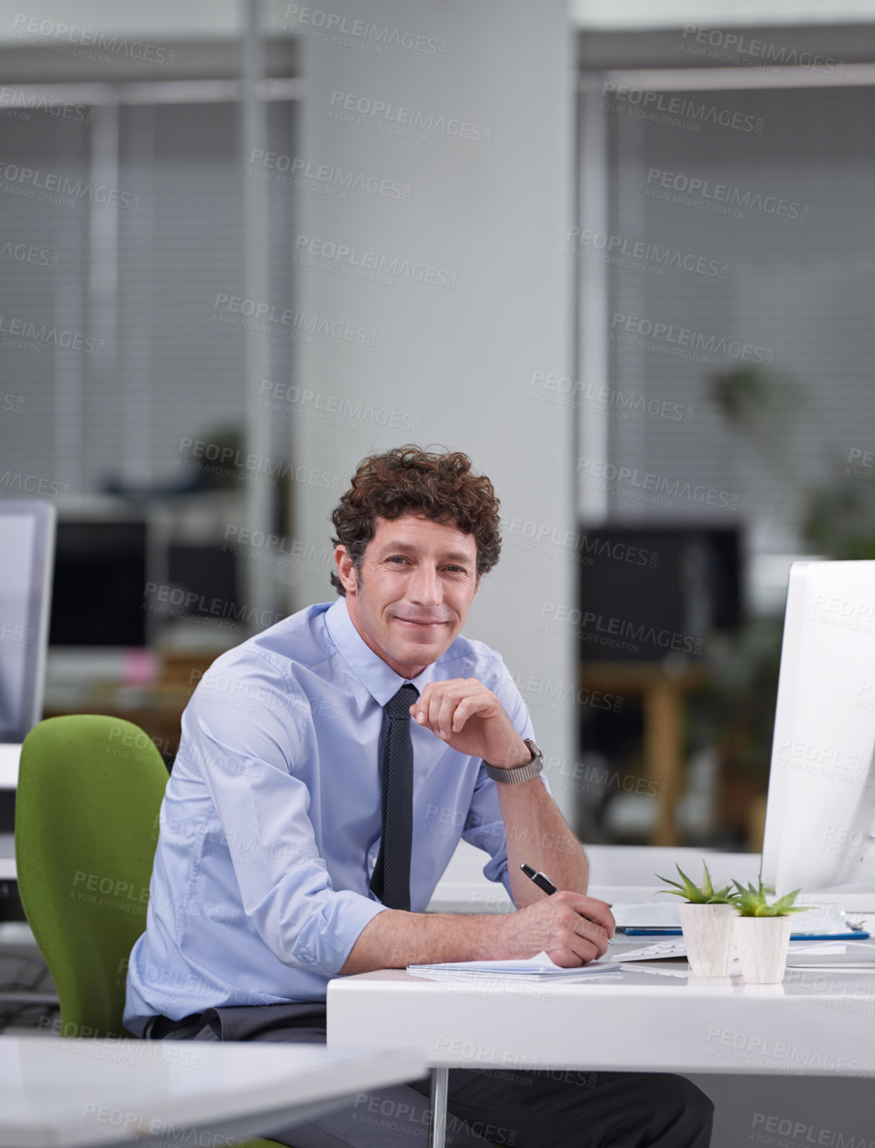 Buy stock photo Cropped shot of a young businessman sitting at his desk