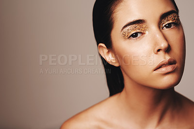 Buy stock photo Woman, makeup and gold glitter in portrait for beauty, cosmetology and glamour with cosmetics on beige background. Eyeshadow, fashion model in studio for art or creativity with shimmer and glow
