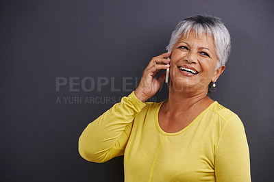 Buy stock photo Smile, phone call and senior woman in studio for communication, good news or gossip. Contact, mockup and elderly female person on mobile conversation with cellphone for talking by black background.