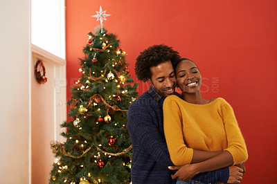 Buy stock photo Couple, Christmas tree and festive holiday in house with happiness fr vacation celebration, gifts or bonding. Man, woman and smile with lighting decoration for winter season event, together or lounge