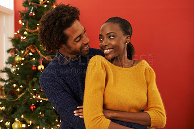 Buy stock photo Couple, hug and Christmas holiday at tree in home for winter break at festive season for bonding, happiness or connection. Man, woman and embrace in living room for relax joy, present or vacation