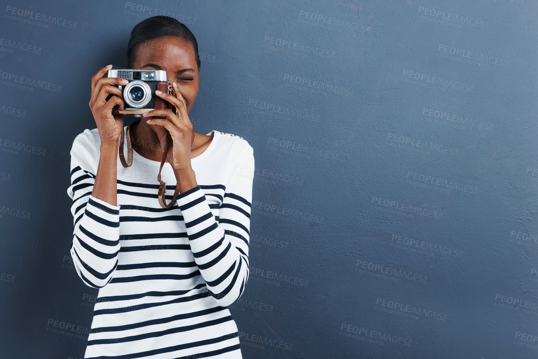Buy stock photo Shot of an attractive young woman taking a photo with a vintage camera