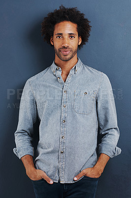 Buy stock photo Black man, portrait and casual for fashion with denim shirt, calm and cool in studio with afro on blue background. African model with smile, pride and pose with hands in pocket and stylish clothes