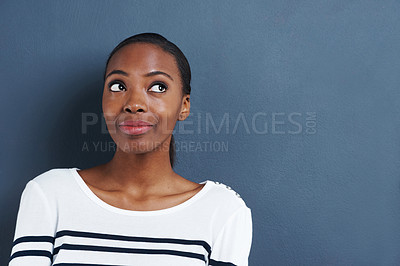Buy stock photo Shot of an attractive young woman looking off to the side on a gray background