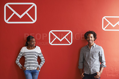 Buy stock photo A young man and woman standing against a red wall full of email signs